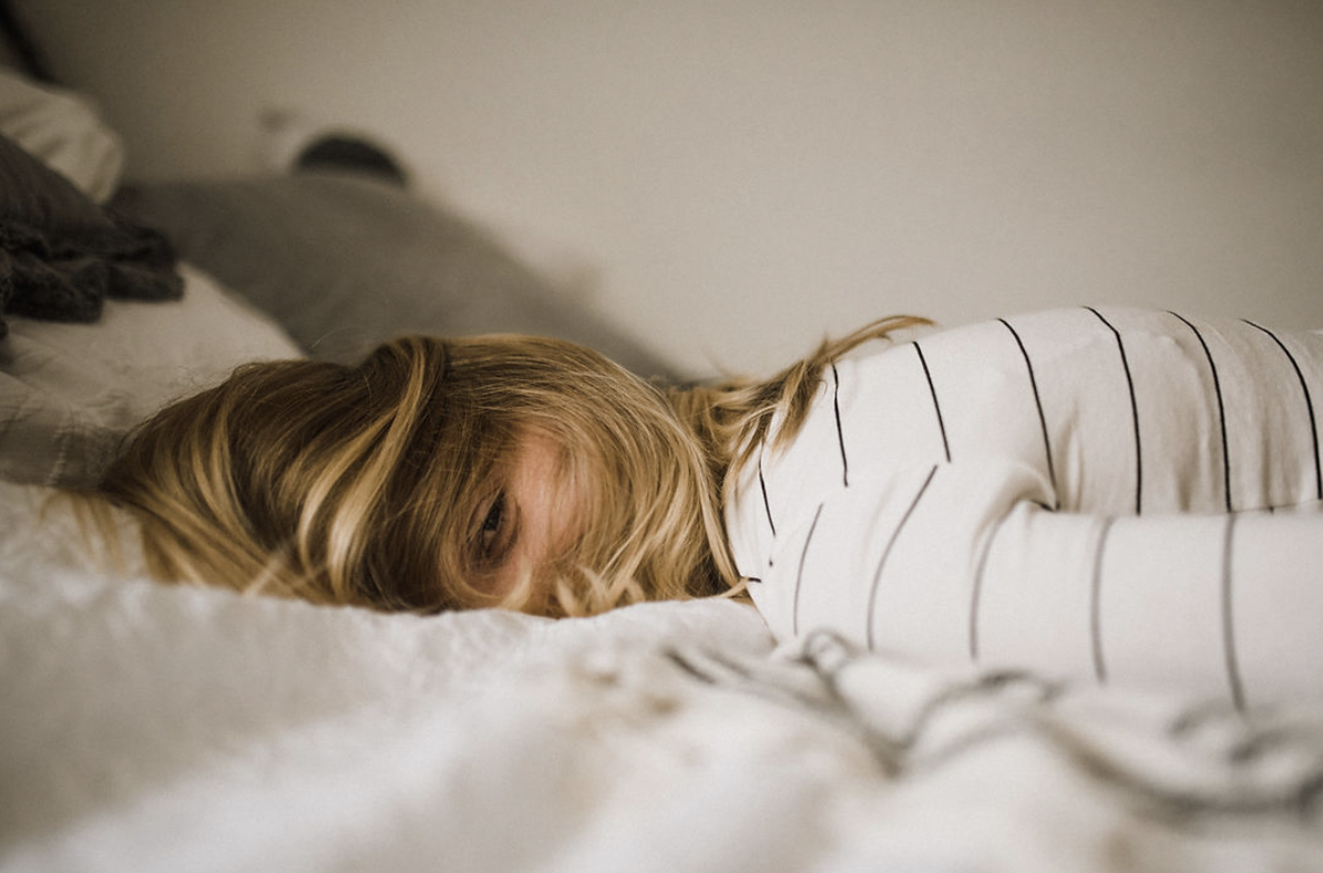 Peaceful sleeping child with blonde hair in white striped pajamas