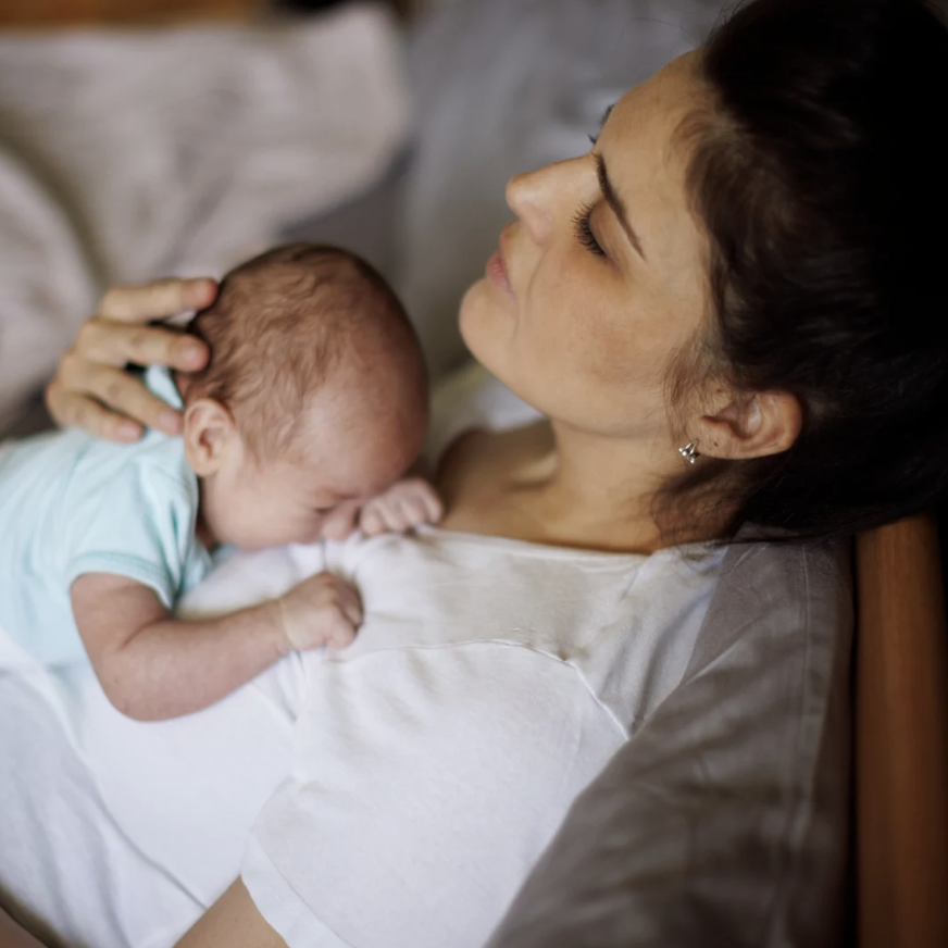 Mother gently holding and bonding with her newborn baby